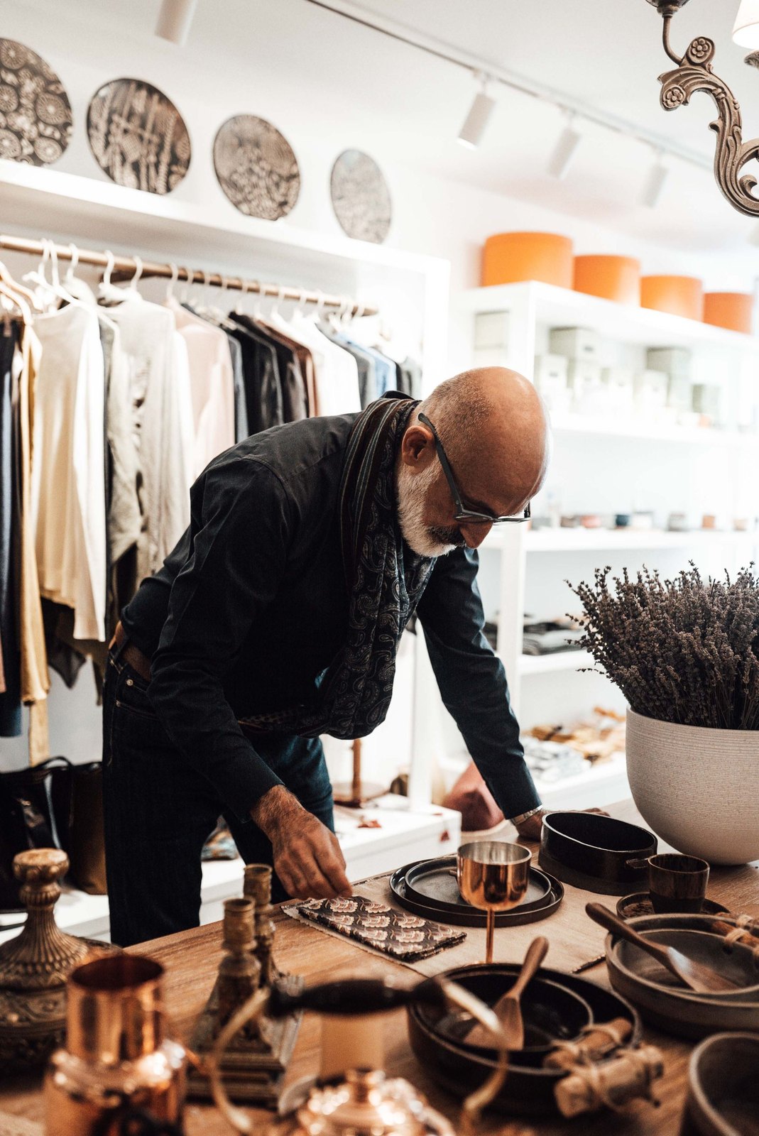 An experienced shop owner arranging merchandise in his boutique