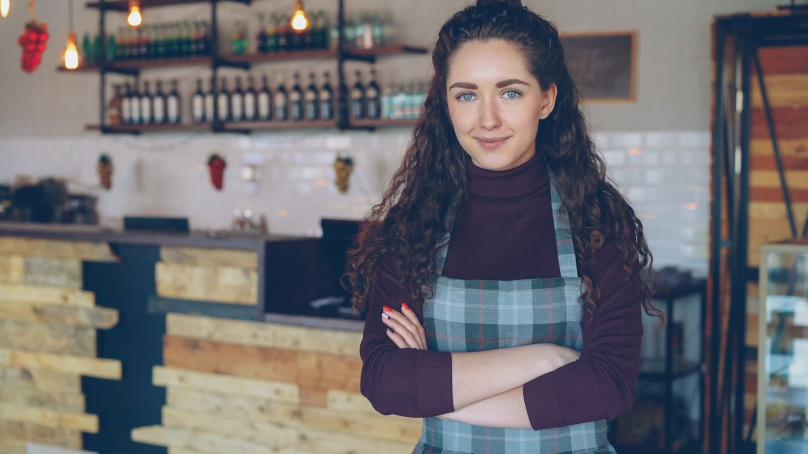 A cafe owner standing at the entrance to her business