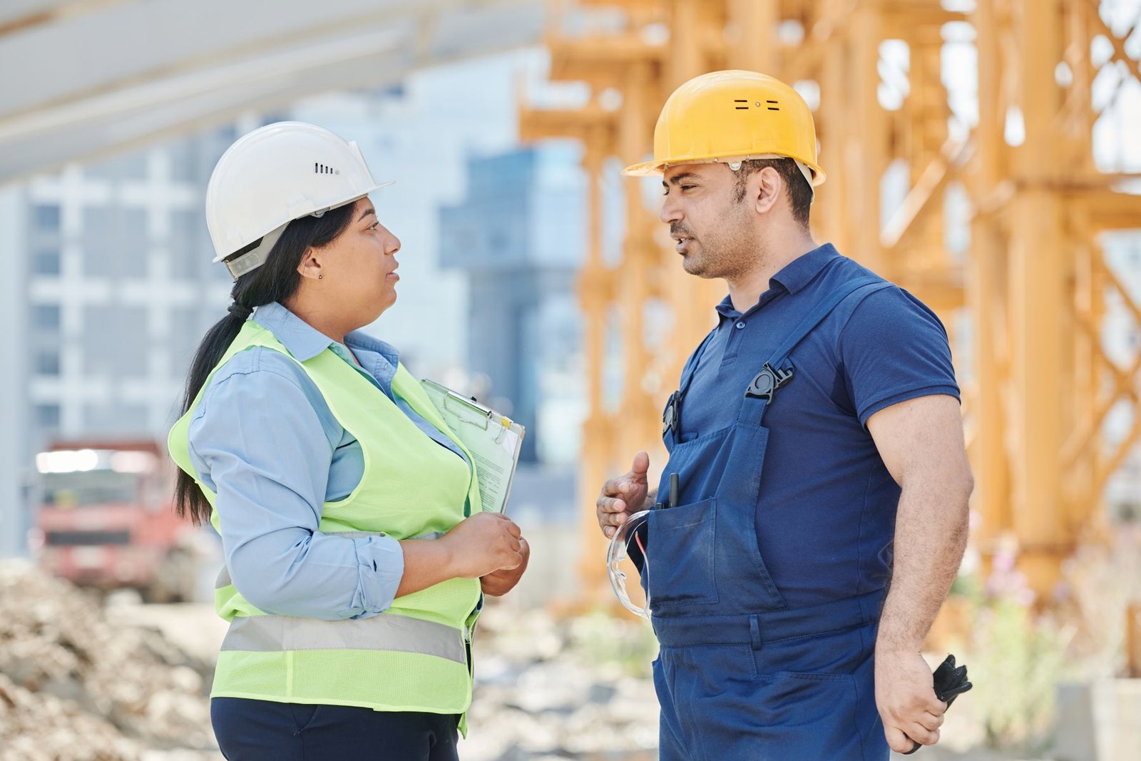 Two experienced construction professionals discussing work at an active job site