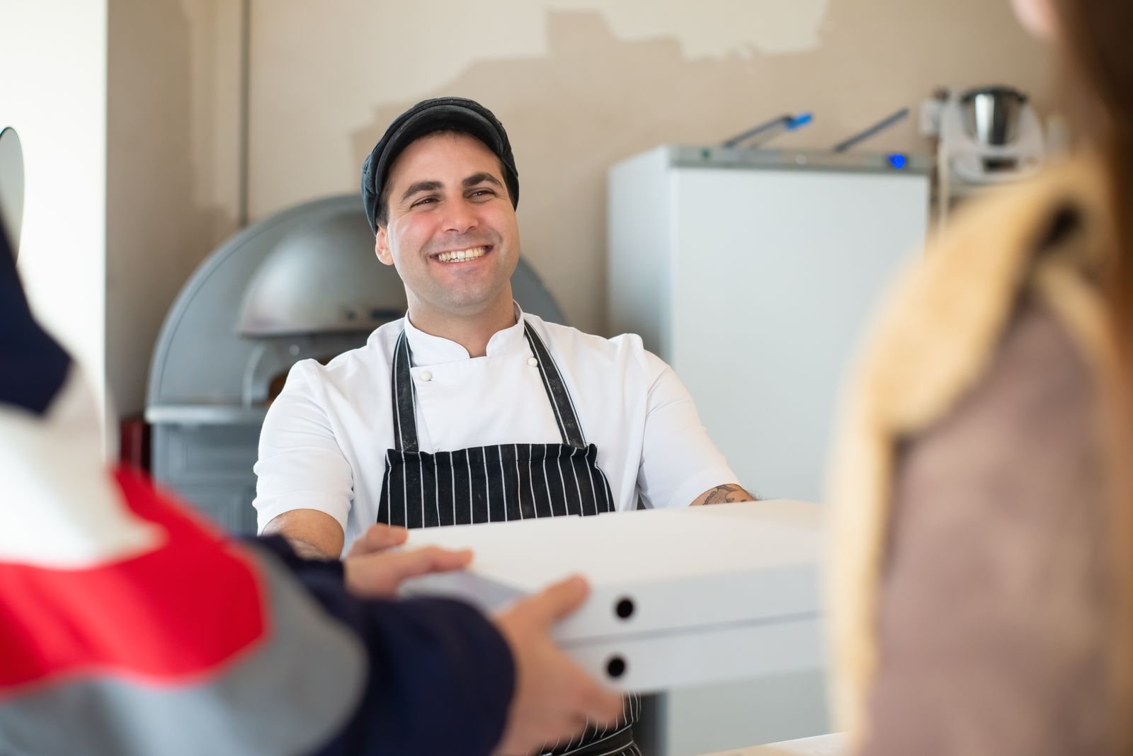 An auto shop owner and two customers working through a request together at the front counter